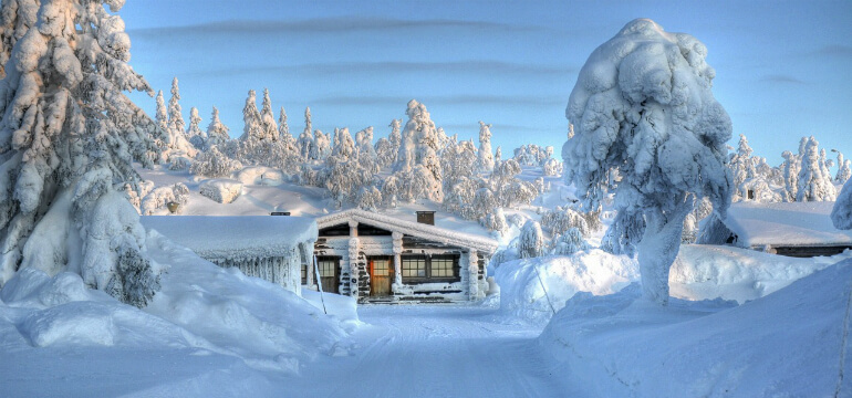 En liten stuga i ett snötäckt vinterlandskap